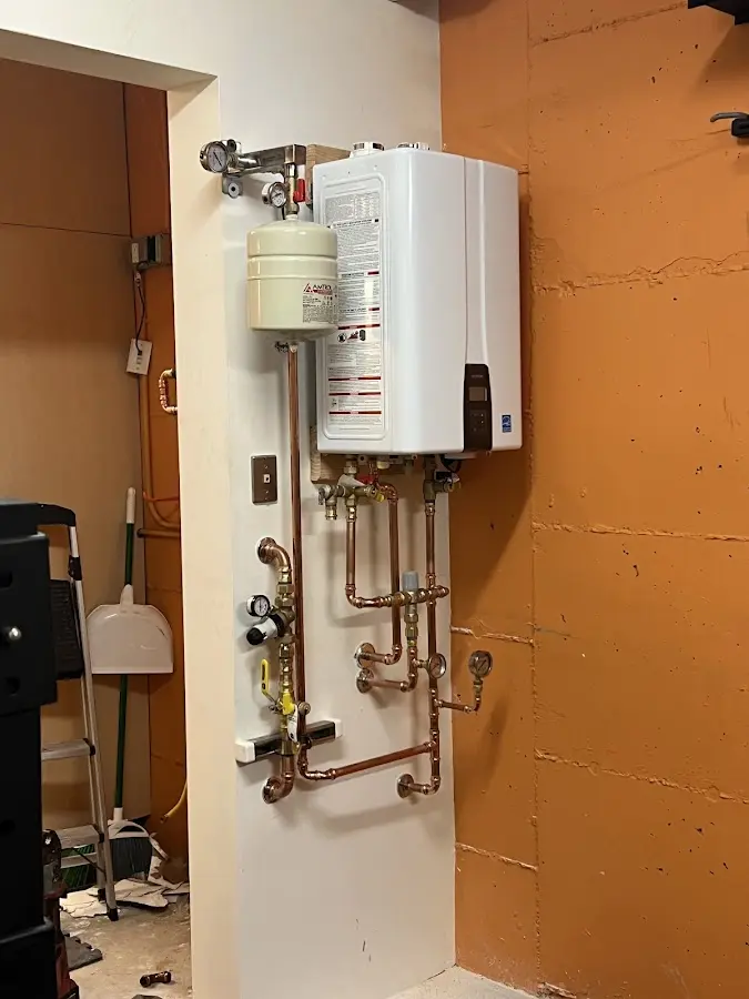 Plumbing technician inspecting water heater connections in Upland